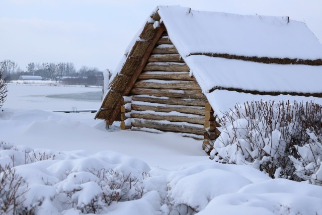 Otulona śniegiem słowiańska chata nad zalewem Maczuły w gminie Leśniowice.
