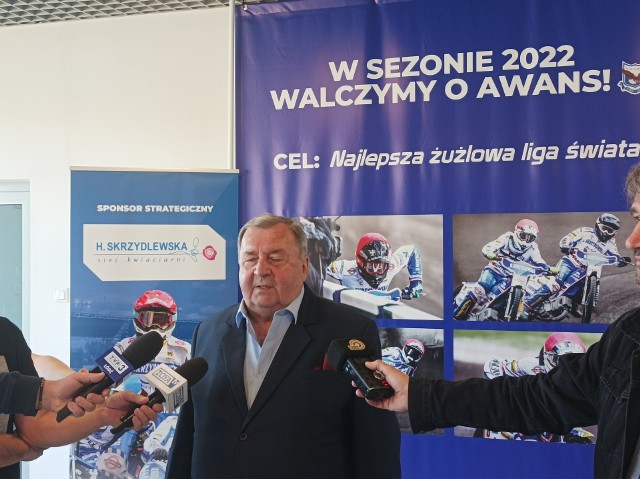 Witold Skrzydlewski przed plakatem:  „W sezonie 2022 walczymy o awans”