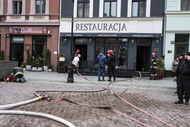 Tuż przed godziną 11 w restauracji "Chleb i Wino" na Rynku Staromiejskim wybuchł pożar. Ogień pojawił się w kuchni, w kanale wentylacyjnym. Na miejscu pracowało 7 zastępów straży pożarnej. Z zadymionych pomieszczeń wyprowadzono jedną osobę, która jest pod opieką służb medycznych. Jak nas poinformowały z jej stanem zdrowia jest wszystko w porządku. Strażacy cały czas szukają źródła ognia. - Z przykrością informujemy, że nasza restauracja w dniu dzisiejszym będzie nieczynna - czytamy na fanpage'u restauracji. - Jednocześnie musimy odwołać wszystkie dzisiejsze rezerwacje. Za wszelkie niedogodności bardzo przepraszamy. W sprawie kolejnych dni będziemy Państwa informować na naszym fanpage'u. - Około godziny 11 otrzymaliśmy zgłoszenie o pożarze przy ulicy Rynek Staromiejski 22. Pożar rozprzestrzeniający się w części parterowej budynku, gdzie znajduje się część restauracyjna. W obrębie grilla i jego systemu wentylacji nastąpiło silne zadymienie. Przy okazji została zadymiona również część apartamentowa na pierwszym piętrze tego budynku. Tam musieliśmy ewakuować jedną osobę. Pożar gasiło siedem zastępów straży pożarnej. Obecnie sytuacja jest opanowana. W tej chwili trwa także zabezpieczanie pogorzeliska oraz ewentualne sprawdzanie kamerą termowizyjną gdzie może rozprzestrzeniać się ewentualny pożar – mówił brygadier Andrzej Seroczyński oficer prasowy Komendanta Miejskiego Państwowej Straży Pożarnej w Toruniu. Autor: mfINFO Z POLSKI - przegląd najciekawszych informacji ostatnich dni w kraju - 20 kwietnia 2017.