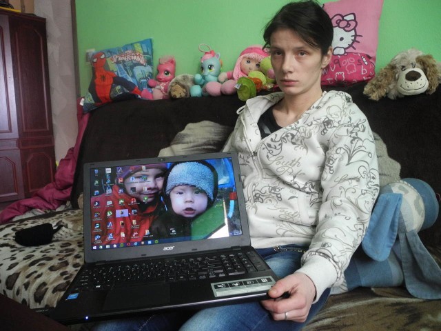 Pani Joanna pokazuje na laptopie zdjęcia swoich małych pociech.