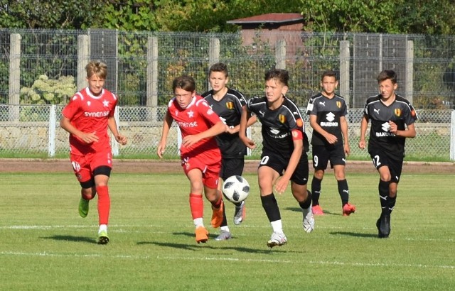 W meczu na szczycie w Centralnej Lidze Juniorów do 15 lat piłkarze KKP Korona Kielce zremisowali z liderem Wisłą Kraków 1:1 (0:1). Wyrównującą bramkę zdobył Marcel Łukawski w 75 minucie z rzutu karnego, a jedenastkę wywalczył Igor Czuba. KKP Korona: Jamróz - Jas, Chałaciński, Sejdziński, Purski, Rożek, Toboła, Łukawski, Kucharczyk, Błaszczyk, Kijewicz, Kościelecki, Czuba, Adach, Niedbała, Słowak, Cerek.Trenerzy Piotr Dutkiewicz i Paweł Mech tak skomentowali to spotkanie: - Wisła od początku spotkania miała przewagę w posiadaniu piłki, ale my umiejętnie się broniliśmy i wyprowadzaliśmy groźne kontrataki. W pierwszej połowie mieliśmy swoje sytuację, ale nie udało się ich zamienić na bramkę.  Wynik do połowy 0:0. W drugiej połowie popełniliśmy błąd przy stałym fragmencie gry i to Wisła prowadziła 1:0. Ale zawodnicy się nie podłamali i zaczęli śmielej atakować bramkę przeciwnika co przyniosło efekt w 68 minucie Jakub Adach umieścił piłkę w bramce, ale sędzia dopatrzył się spalonego, a już w 75 minucie po faulu na Igorze Czubie sędzia podyktował rzut karny. Karnego na bramkę zamienił Marcel Łukawski. Brawa dla całego zespołu za walkę do samego końca.Zachęcamy do obejrzenia galerii zdjęć i wideo z tego meczu - szczegóły na kolejnych slajdach. (dor)