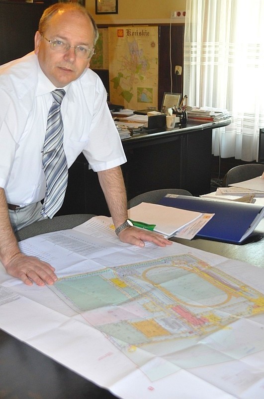 Burmistrz Krzysztof Obratański pokazuje plany budowy nowego boiska na stadionie przy ulicy Południowej.