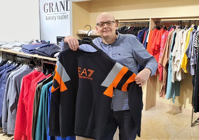 Jarosław Panek, współwłaściciel outletu Grand w Kielcach, prezentuje bluzy Emporio Armani EA7 w rozmiarze 3 XL.