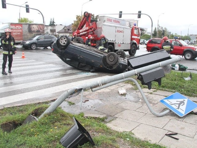 Samochód zajmujący dwa pasy jezdni ustawili na koła strażacy.