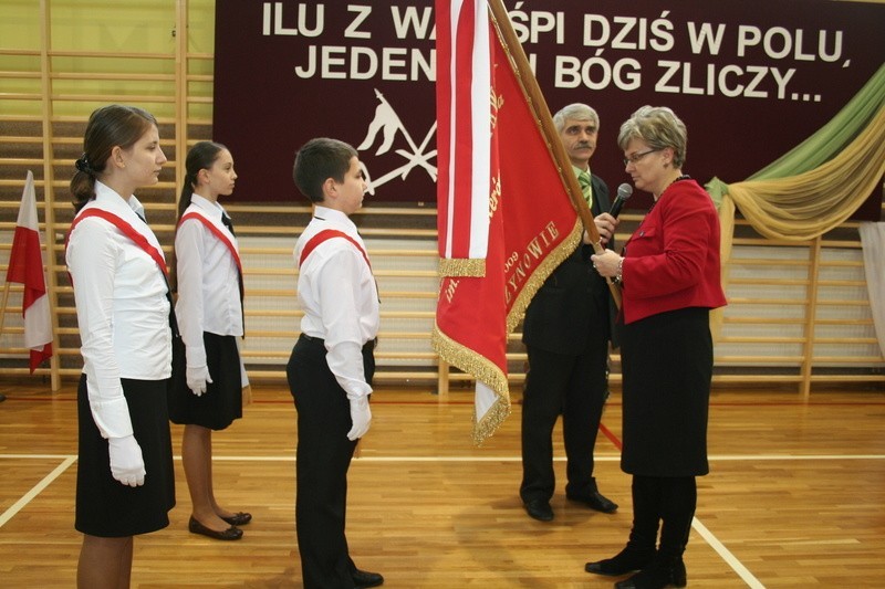 Dyrektor szkoły, JOlanta Dawid przekazuje sztandar uczniom