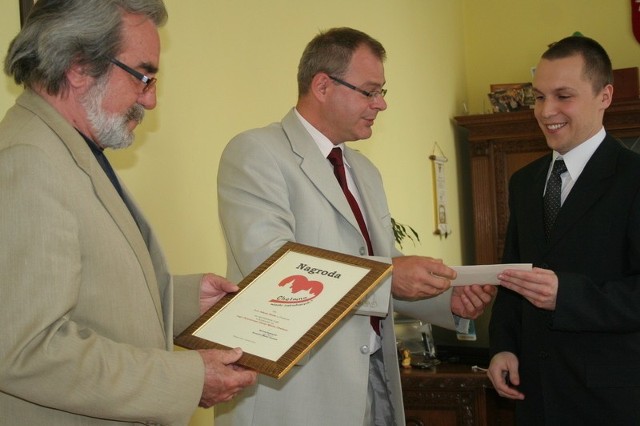 Adam Rink odebrał nagrodę od burmistrza Mariusza Kędzier-skiego i przewodniczącego komisji konkursowej Waldemara Piotrowskiego