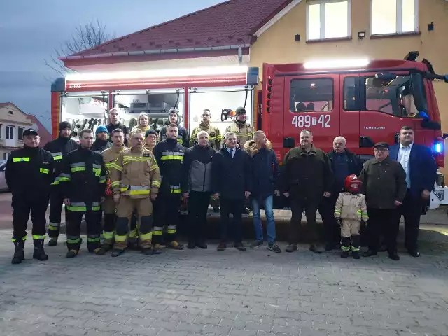 Uczestnicy przywitania nowego wozu strażackiego stanęli przy nim do pamiątkowej fotografii.