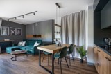 Pomysł na nowoczesne mieszkanie w stolicy. Modne połączenie salonu i kuchni. Styl loftowy i drewno rządzi we wnętrzu miłośników kotów