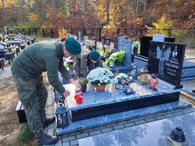 Żołnierze zapalili znicz na grobie Sebastiana Marczewskiego, pochowanego na cmentarzu komunalnym w Stalowej Woli