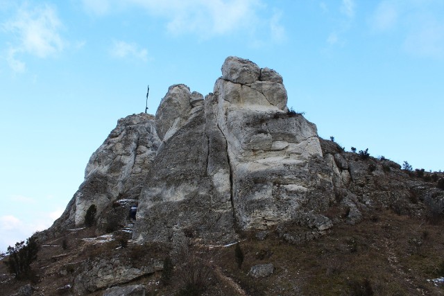Jurajski Mały Giewont posiada charakterystyczny układ szczytowych skał, który przypomina słynnego „śpiącego rycerza” z nad Zakopanego. Tak, jak tatrzańskiego bliźniaka, górę zwieńczono żelaznym, ażurowym krzyżem. To miejsce zdecydowanie warto odwiedzić! Zobaczcie zdjęcia.>>>>>>>>>>>>>