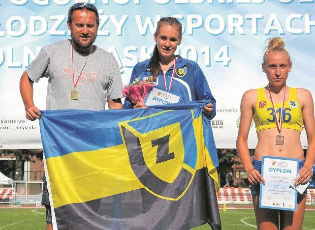 Helena Dalke z trenerem Jackiem Lewandowskim na pierwszym miejscu podium po biegu na 400 m przez płotki.