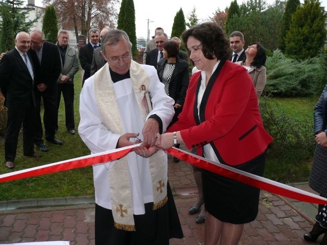 Teresa Baran, dyrektor przedszkola w Sobkowie oraz ksiądz Leszek Molenda, proboszcz parafii w Sobkowie dokonują przecięcia wstęgi.