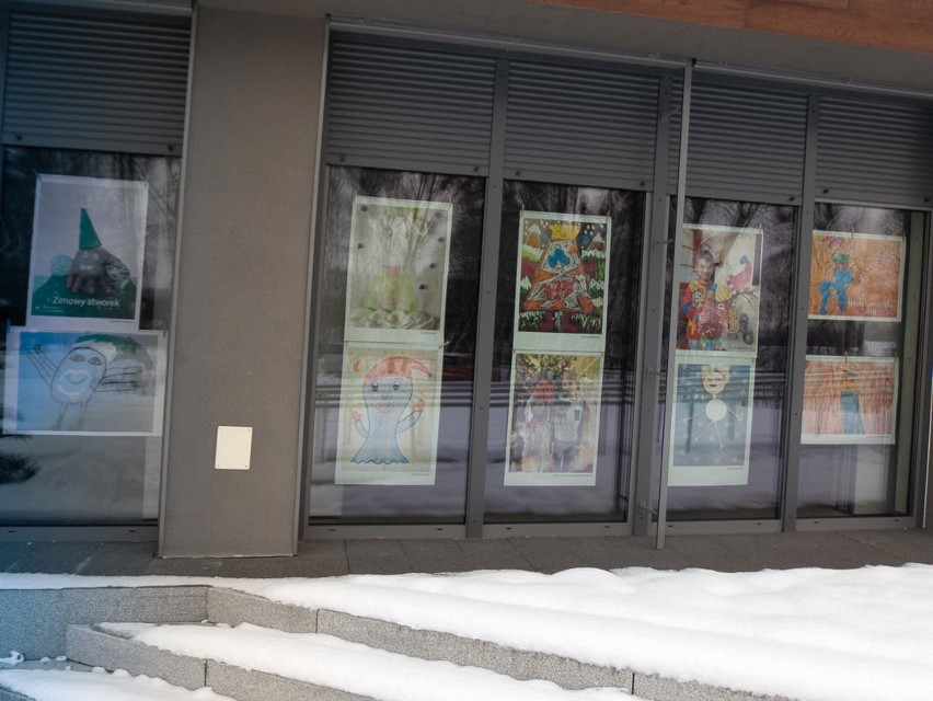 Zimowe stworki wyglądają zza okien Lądowiska Kultury w Redzikowie. Wystawa prac pokonkursowych