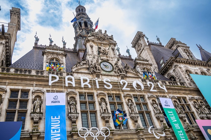 Fasada ratusza w Paryżu ozdobiona kołami olimpijskimi