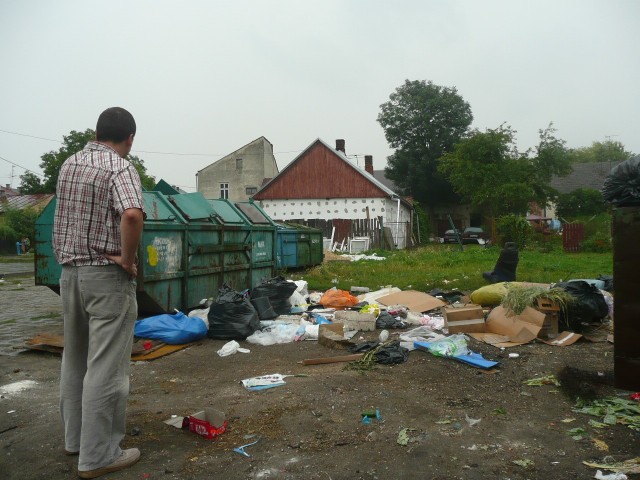 Na placu pomiędzy kontenerami znajdują się zwały śmieci, których nikt nie sprząta