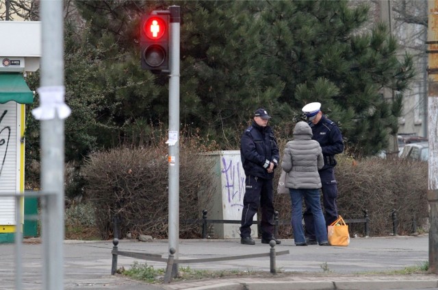 Policjanci z kobietą, która przeszła na czerwonym świetle.