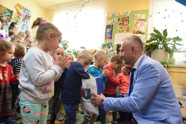 Prezydent Ludomir Handzel częstuje dzieci cukierkami podczas spotkania w bibliotece