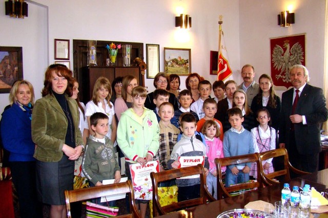 Młodzi artyści pozowali do pamiątkowego zdjęcia z burmistrzem i swoimi opiekunami.