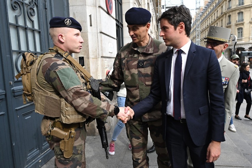 Premier Francji Gabriel Attal (po prawej), obok gubernatora...