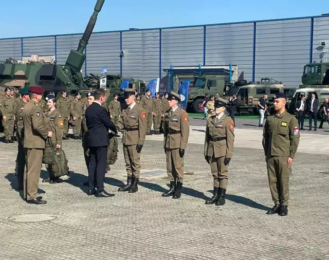 Minister Mariusz Błaszczak składa gratulacje wyróżnionym uczniom klas mundurowych.