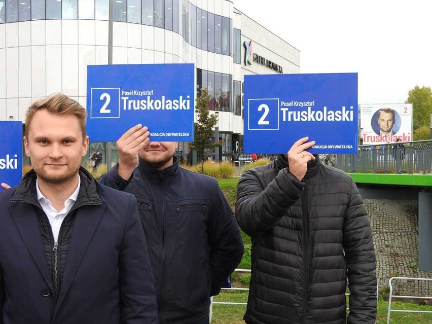 Krzysztof Truskolaski na plakacie wyborczym (w tle) podaje,...