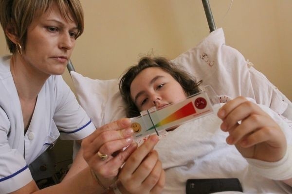 Pielęgniarka Iwona Łapińska uczy 12-letnią Natalię Czechowicz, jak posługiwać się specjalną linijką do pokazywania bólu pooperacyjnego