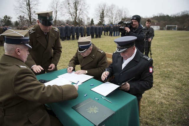 Pułkownikowie Mirosław Sowiński (z lewej) i Eryk Hoffmann podpisują rozkazy przed przedstawicielem Inspektoratu Wsparcia Sił Zbrojnych pułkownikiem Sławomirem Łachem