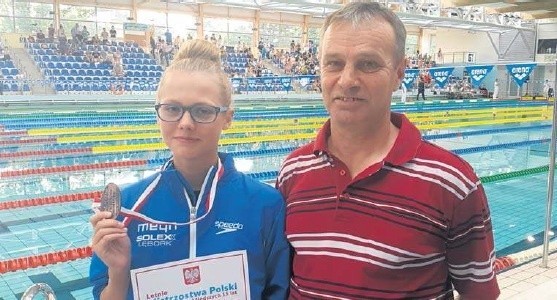 Weronika Hallmann z wielką przyjemnością prezentuje brązowy medal na pływalni w Ostrowcu Świętokrzyskim.