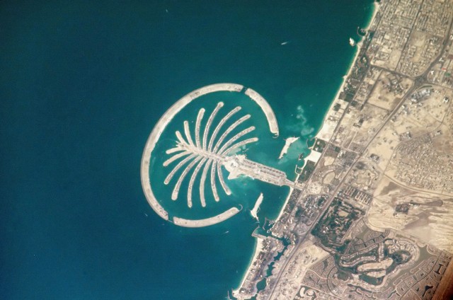 Palma Jumeirah u wybrzeży Dubaju to budowana od 2001 roku sztuczna wyspa w kształcie palmy pełna hoteli i luksusowych osiedli. Domy wykupiło tu wiele znanych osób, m.in. David Beckham. Budowa wyspy spowodowała jednak ogromne szkody ekologiczne w regionie, a samej wyspie nieustannie zagraża erozja, której zapobieganie jest bardzo kosztowne.Licencja zdjęcia: https://creativecommons.org/publicdomain/mark/1.0/deed.pl