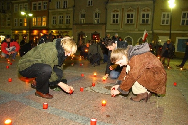 Uczestnicy uroczystości zapalili na Rynku znicze ułożone w napis &#8220;Pamiętamy 10.04.2010&#8221;.