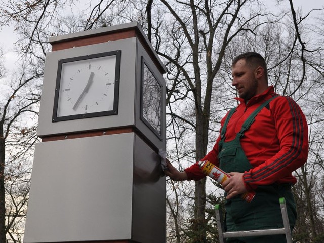 Arkadiusz Łubniewski z koszalińskiej firmy Anox czyści zegar zamontowany w parku w Szczecinku. 