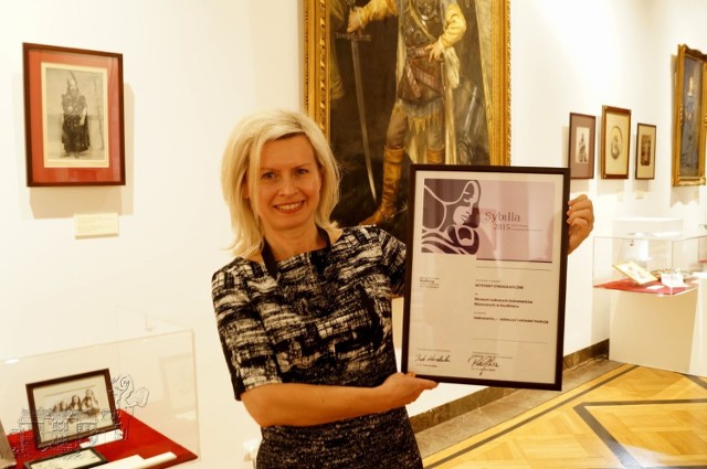 Aneta Oborny, dyrektor szydłowieckiego Muzeum Ludowych Instrumentów Muzycznych prezentuje ministerialną nagrodę.