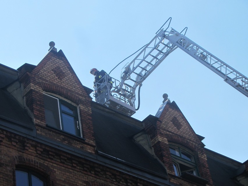 Ponad dwudziestu strażaków gasiło ogień na dachu kamienicy...