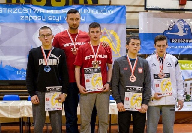 Adam na podium z trenerem Jakubem Janiszewskim (czerwone koszulki)