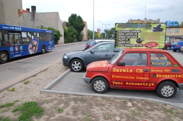 Nowy parking przy ulicy Jana Pawła II. Pierwsze z brzegu miejsce okupuje mały fiat - reklama.