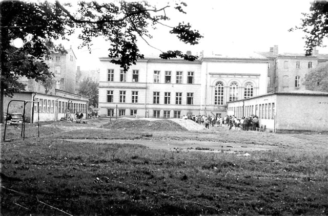 Zdjęcie zrobione w 1969 roku przedstawia budynek szkoły od strony dziedzińca.