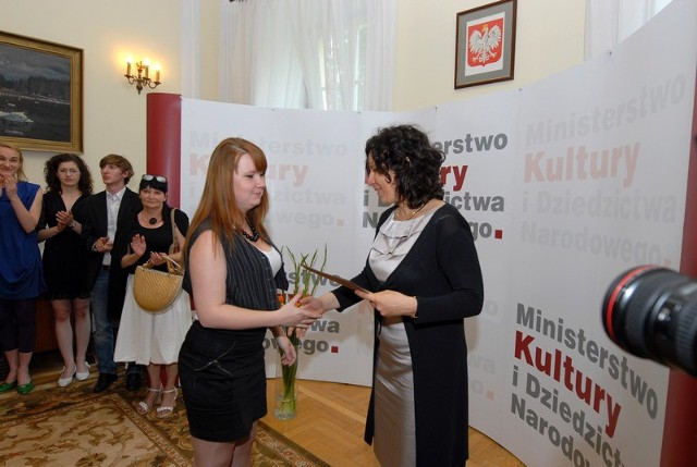 Dyplom o przyznaniu stypendium wręcza Zuzannie  Monika Smoleń, podsekretarz Stanu w  Ministerstwie Kultury i Dziedzictwa Narodowego