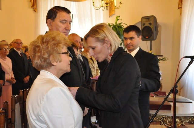 Wiceburmistrz Ewa Kondek dekoruje medalami Danutę i Mariana Białów.