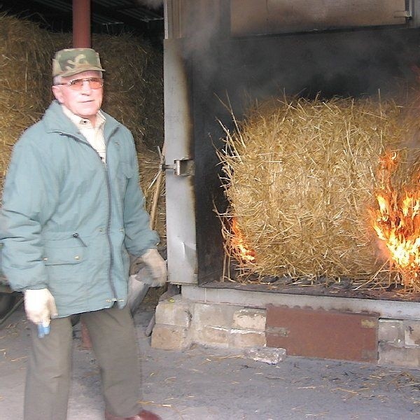 Władysław Koziński podczas obsługi pieca  na słomę
