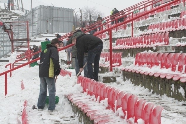 Kibice Widzewa podczas odśnieżania stadionu.