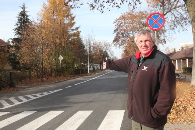 Pan Konrad pokazuje ścieżkę rowerową (po drugiej stronie jezdni), przez którą nie ma parkingów