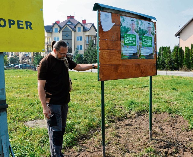 Grzegorz Buczek przy przestawionej tablicy osiedlowej