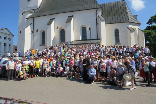 Około 350 osób wzięło udział w 201. pielgrzymce ze Staszowa do Sulisławic. Do Sanktuarium Maryjnego mieszkańcy zanieśli rożne modlitwy i intencje. Już w piątek, 11 czerwca o godzinie 19 odbyła się msza święta na cmentarzu w Pocieszce. Natomiast w sobotę pielgrzymi ruszyli w trasę. Zanim jednak to nastąpiło wierni wzięli udział we mszy świętej w intencji zmarłych w czasie zarazy cholery, która panowała 201 lat temu w Staszowie oraz w intencji pielgrzymujących. Tradycyjnie na pierwszym postoju nad jeziorem w otoczeniu lasu odbył się chrzest nowicjuszy – czyli osób, które po raz pierwszy uczestniczyły w pielgrzymce. Każdy nowy pątnik został polany wodą i wybrał sobie pielgrzymkowe imię. W czasie marszu pielgrzymi modlili się, śpiewali i czytali liczne intencje, za którymi ma się wstawić Matka Boska Sulisławska. W godzinach popołudniowych, pielgrzymi doszli do krzyża staszowskiego, który stoi w miejscu krzyża ustawionego tam przez pielgrzymów pierwszej, historycznej pielgrzymki do Sulisławic. Wśród wędrujących znalazł się między innymi, burmistrz Staszowa Leszek Kopeć, który co roku uczestniczy w tych wydarzeniach. Przypomnijmy, że zwyczaj pielgrzymowania do Sanktuarium Maryjnego w Sulisławicach wywodzi się z czasów, kiedy w Staszowie panowała epidemia cholery. Staszowianie wyruszyli wtedy z drewnianym krzyżem do tego świętego miejsca w intencji ustąpienia zarazy. Kiedy kordon sanitarny nie wpuścił mieszkańców Staszowa do Sulisławic, ustawili oni krzyż w miejscu, w którym ujrzeli wieże Sanktuarium. Podczas powrotu do domu dotarła do nich wieść o ustąpieniu epidemii. Od tamtej pory na zakończenie oktawy Bożego Ciała kolejne pokolenia mieszkańców Staszowa pielgrzymują do Matki Boskiej Sulisławskiej.Więcej zdjęć z pielgrzymki na kolejnych slajdach>>>