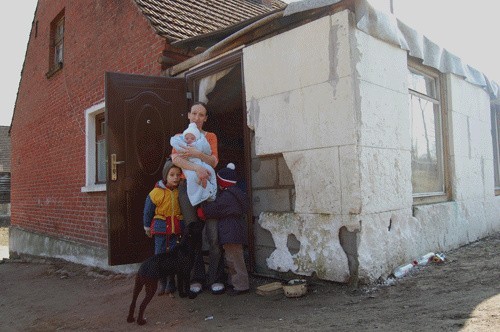 Barbara Marcuch z dziećmi przed samowolnie wybudowanym gankiem.