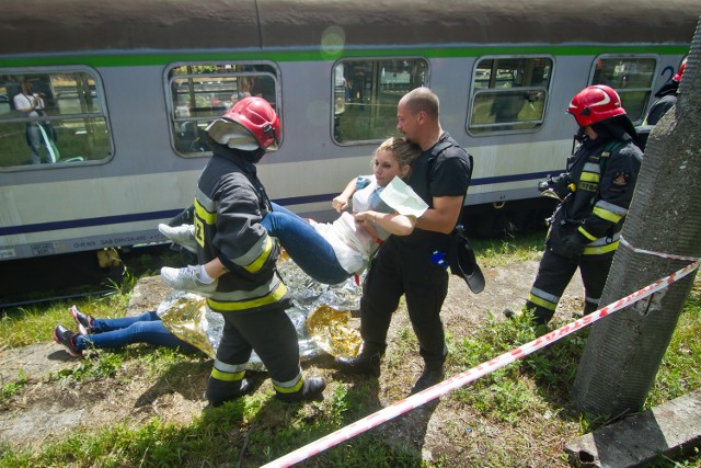 Pociąg zatrzymał się  wczoraj tuż przed stacją Bydgoszcz-Główna obok cmentarza przy Ludwikowie. Krótko po godzinie 11 w jednym z wagonów padły strzały, rozległy krzyki pasażerów, a napastnik uzbrojony w karabin maszynowy wychylił się przez drzwi i wrzasnął do gapiów gromadzących się przed składem: „Wyp.... wszyscy stąd!”. Padła kolejna seria z karabinu. Nastąpiła eksplozja, a z okien wagonu wydostała się chmura siwego dymu. Po kilku minutach na miejscu był oddział SAT, czyli sekcji antyterrorystycznej. Zamaskowani i uzbrojeni po zęby szturmowcy podzielili się na dwa pododdziały. Weszli do wagonu dwoma wejściami. Napastnik po wymianie ognia został pojmany. Policjanci zaczęli przeczesywać wagon w poszukiwaniu rannych. Na miejsce dotarła straż pożarna i ratownicy pogotowia. Ze składu zaczęto wynosić rannych. Kilka osób, które odniosły najcięższe obrażenia - łącznie z ranami amputacyjnymi nóg i rąk - na sygnale zabrano do szpitali. Pozostałych poszkodowanych strażacy i ratownicy medyczni układali na skarpie obok pociągu odbitego z rąk terrorysty.  Taki był scenariusz ćwiczeń, które wczoraj zostały przeprowadzone na bocznicy kolejowej między stacjami Bydgoszcz-Leśna i Bydgoszcz-Główna. - To były ćwiczenia, a nie pokaz - zaznaczał wczoraj podinsp. Tomasz Krajewski, z Komendy Wojewódzkiej Policji w Bydgoszczy, dowodzący akcją: - Ani policja, ani pogotowie nie wiedziało, co zastanie na miejscu. (mc)