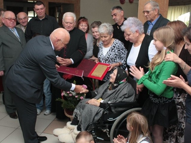 Burmistrz Sandomierza Jerzy Borowski wręcza pani Marii list gratulacyjny od premiera Donalda Tuska.