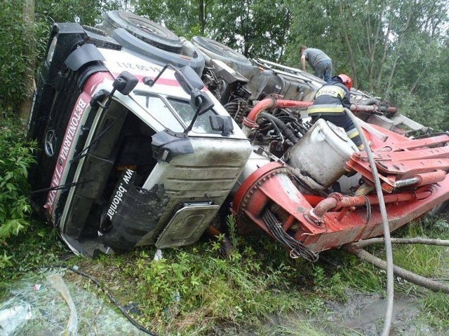 Kierowca trafił do szpitala. By uratować bardzo kosztowny samochód strażacy wydobywali z gruszki beton i utwardzali nim trasę dla dźwigu mającego ponieść  wywrócony samochód.