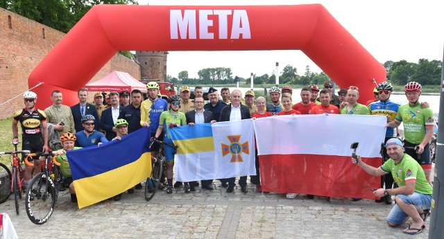Uczestnicy akcji rowerowej wraz z oficjelami, którzy powitali ich przy malborskim zamku.