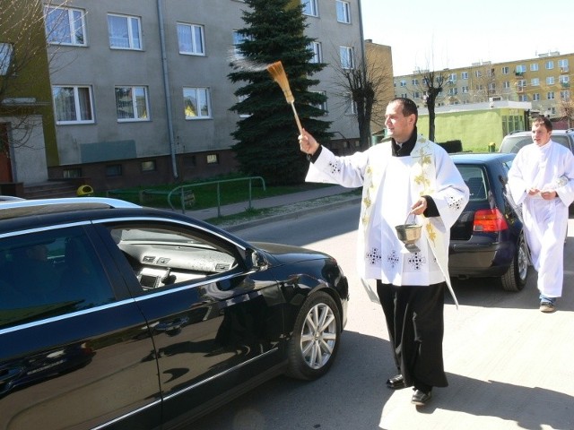 Ksiądz Michał Warchoł święci pojazdy stojące na ulicy Bugaj w Suchedniowie. Stały jeszcze kilkaset metrów od parkingu przy kościele.
