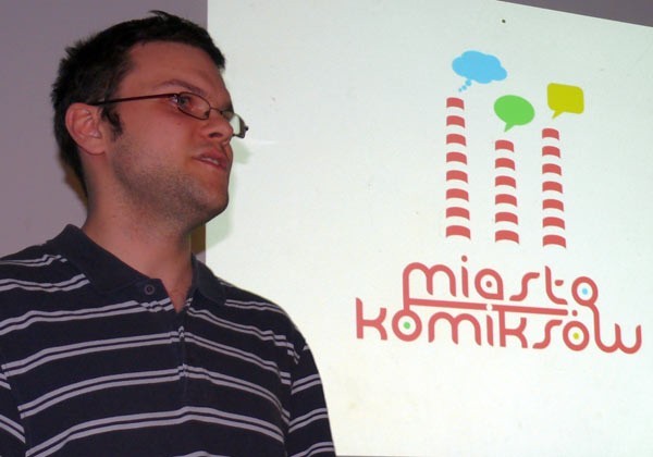 Jakub Woynarowski z wymyślonym przez siebie logo konkursu.
